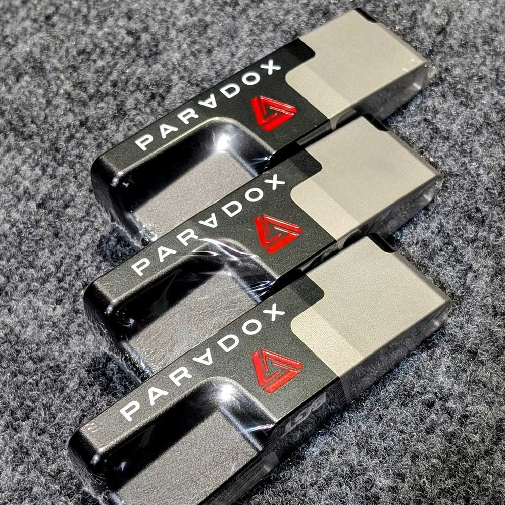 Three BGT Paradox Blade Putters stacked on a gray surface