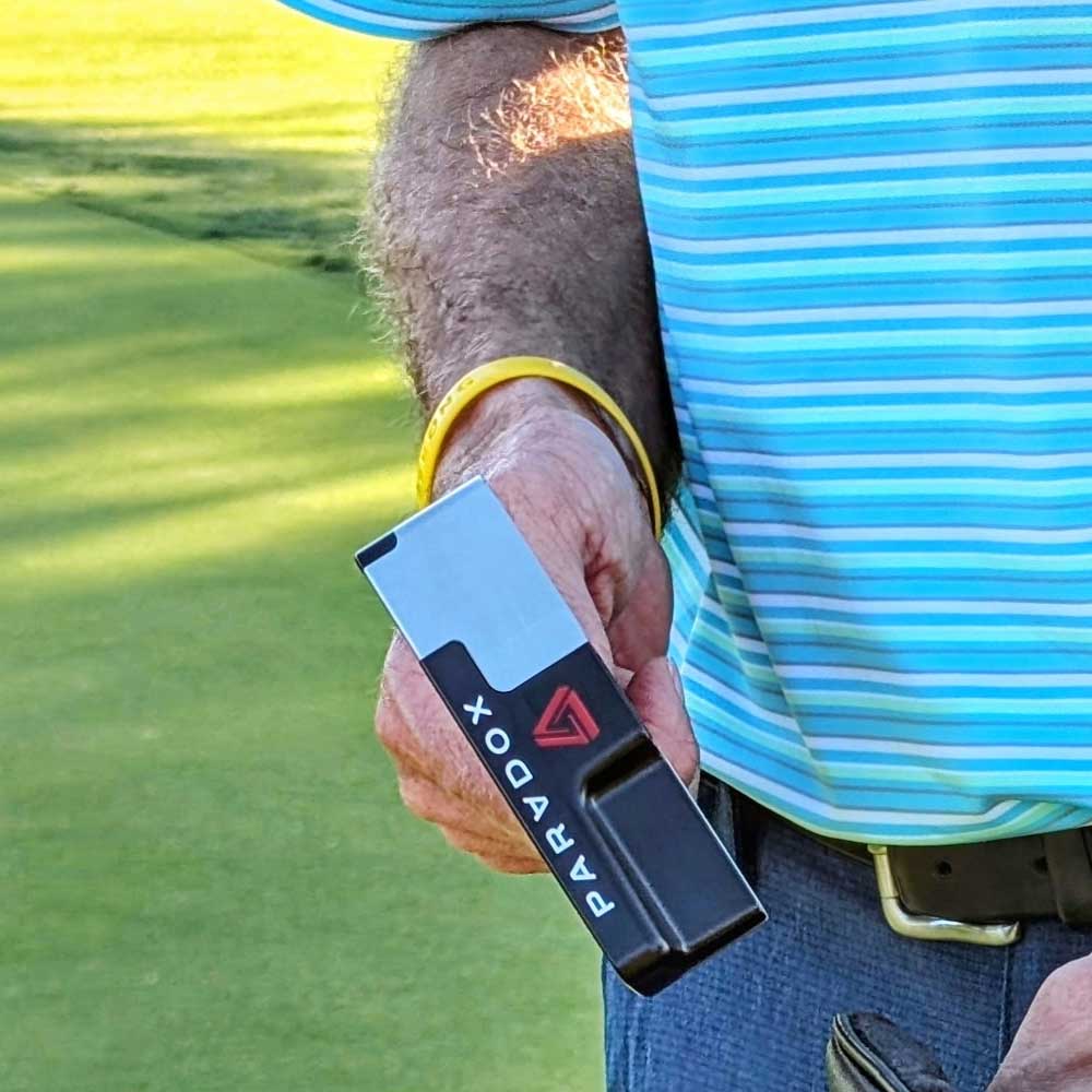 Person holding a BGT Paradox Blade Putters on a golf course