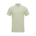 Male model wearing a light grey Hove Performance Polo and black golf shorts by Fenix XCell, standing confidently poolside in a tropical resort setting, styled for an upscale golf lifestyle
