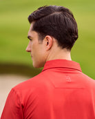 Fenix XCell red performance golf polo featuring moisture-wicking fabric and tailored athletic fit.