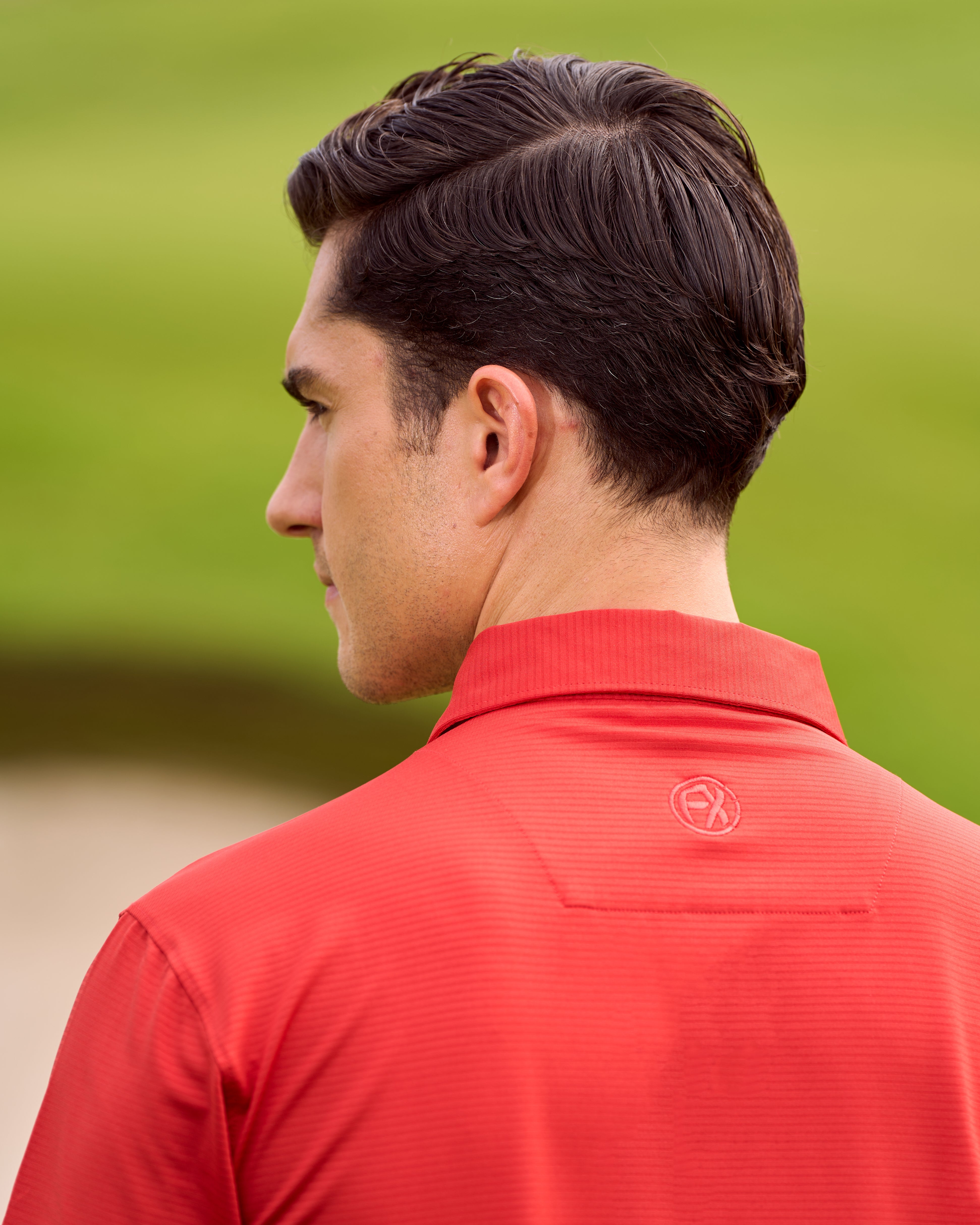 Fenix XCell red performance golf polo featuring moisture-wicking fabric and tailored athletic fit.