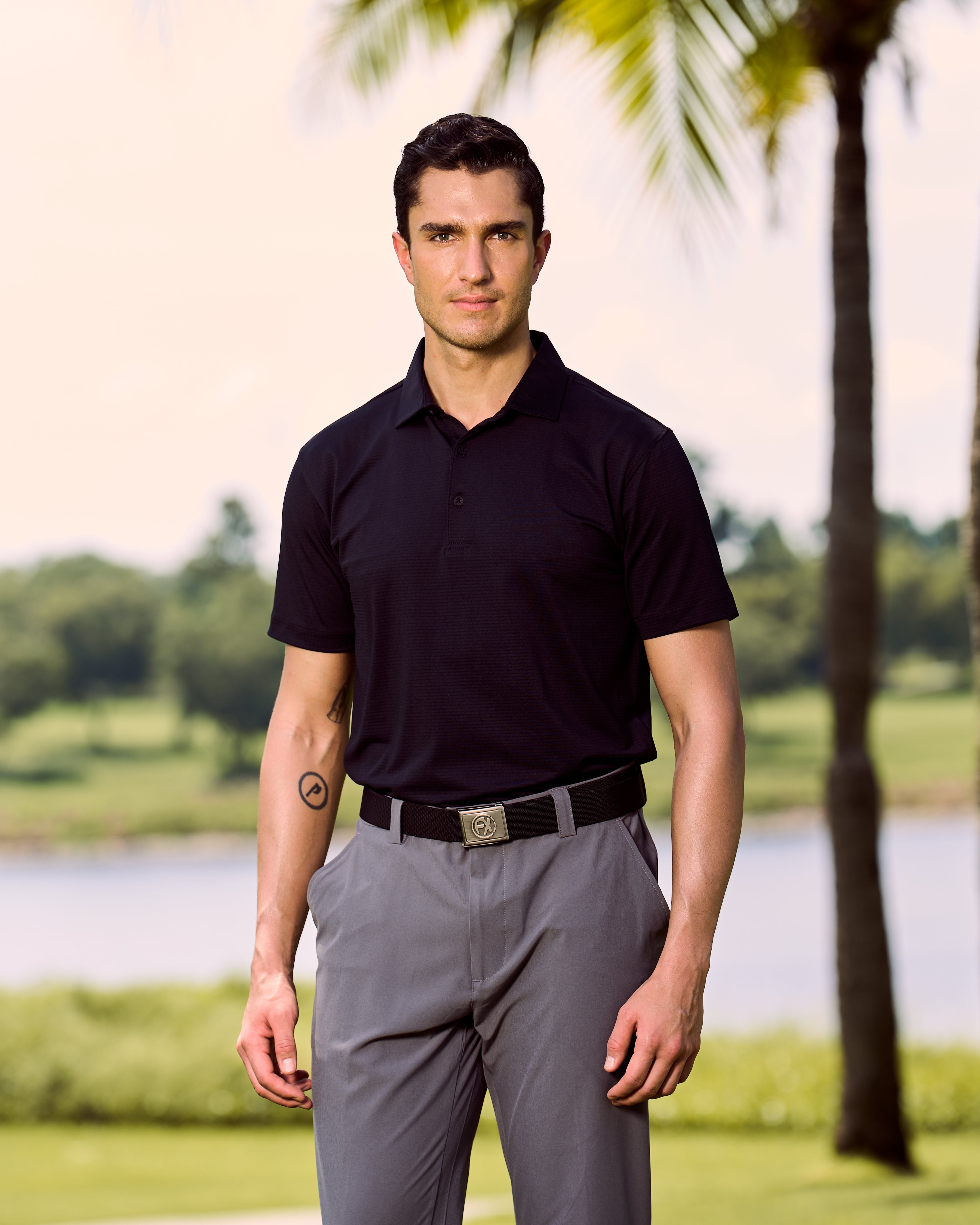 Fenix XCell black performance golf polo featuring moisture-wicking fabric and tailored athletic fit.