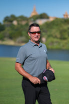 Model on a golf course wearing the slate grey nantucket polo with premium moisture-wicking fabric and tailored athletic fit.
