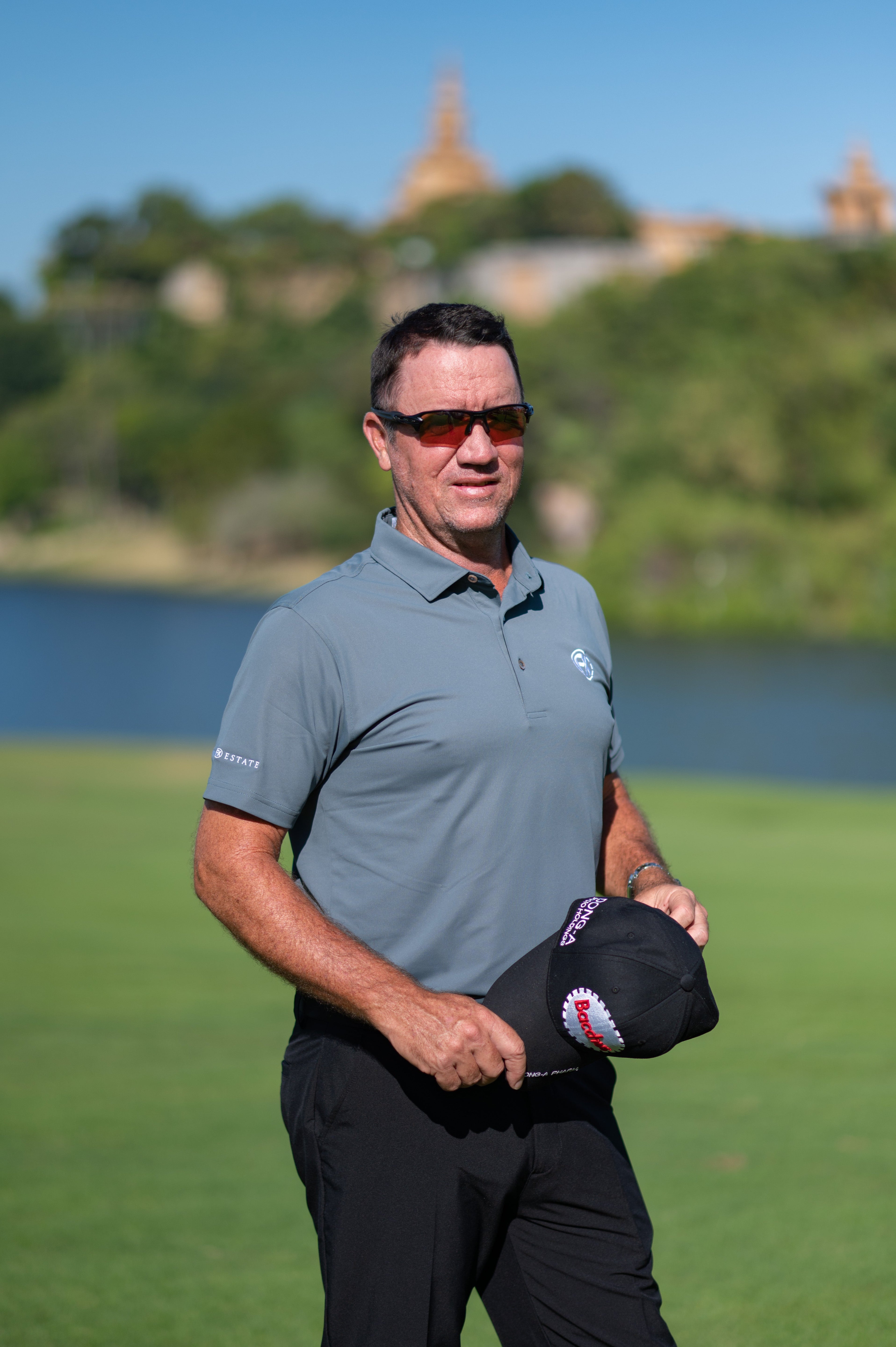 Model on a golf course wearing the slate grey nantucket polo with premium moisture-wicking fabric and tailored athletic fit.